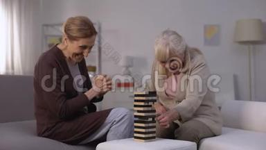 两个快乐成熟的女人在集体游戏中玩，闲暇时间在养老院
